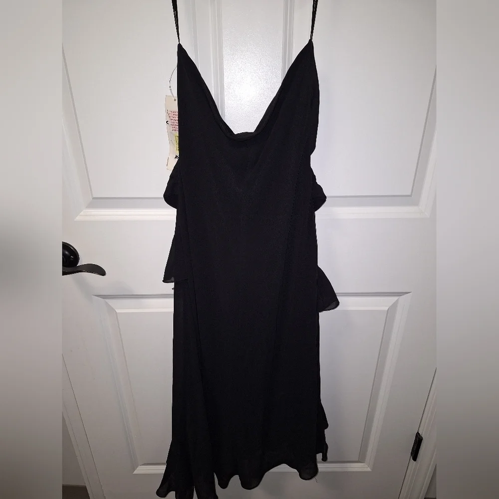 A Jeffrey and Dora asymmetrical Tiered black midi dress in a size 10. It's NWT.